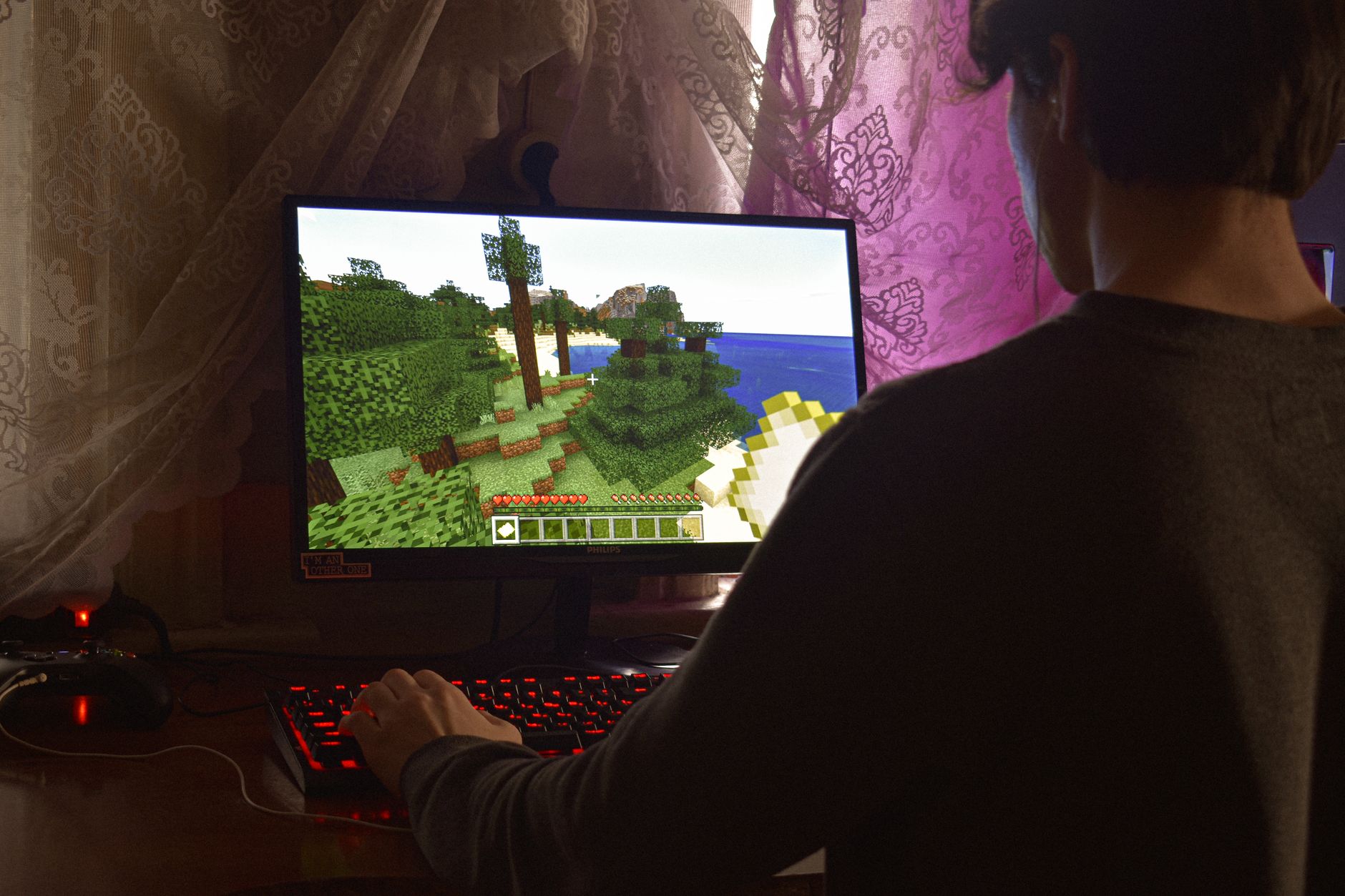 Un jeune homme jouant intensément à un jeu vidéo sur PC à l'intérieur. Capturant l'essence de la technologie et de la concentration.